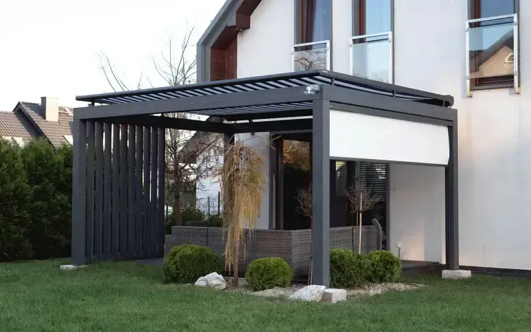 Pergola grafitowa na tarasie w Krakowie w artykule Jak dopasować zadaszenie tarasu do bryły domu.