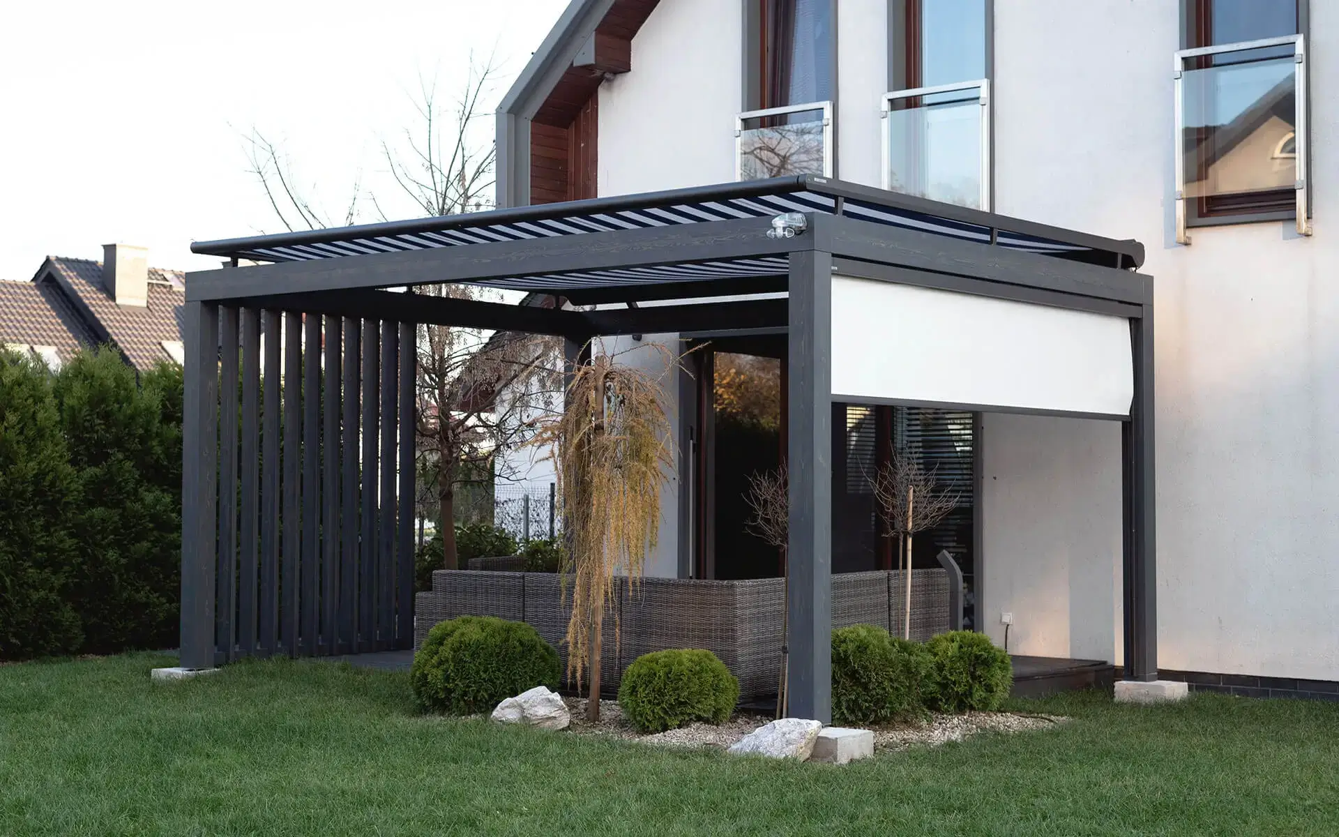 Pergola grafitowa na tarasie w Krakowie w artykule Jak dopasować zadaszenie tarasu do bryły domu.