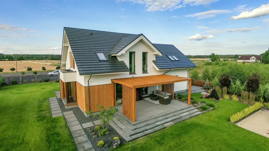 Drewniana pergola tarasowa Pinegard przy domu — widok z góry na zadaszenie i schody do ogrodu.